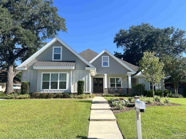 348 Grande Oaks Blvd, Cantonment, FL 32533 - craftsman inspired home with board and batten siding, a front lawn, stone siding, and covered porch