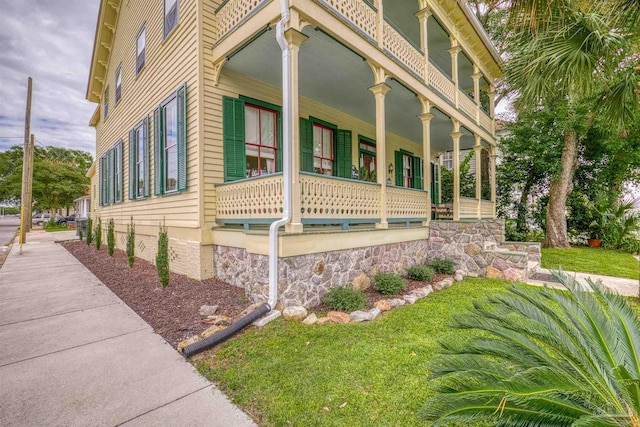 view of property exterior with a yard and a porch