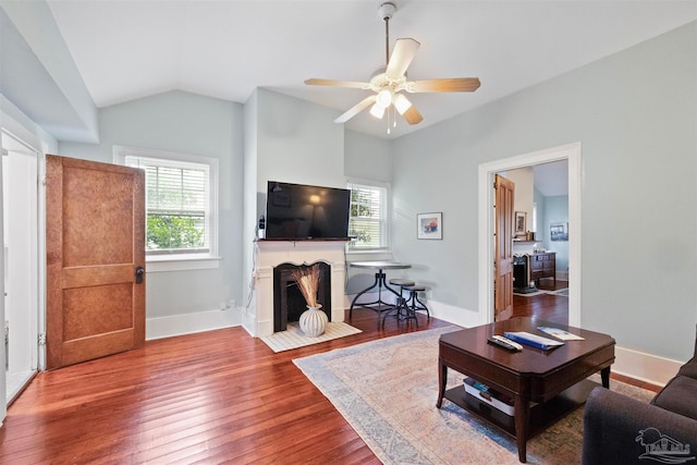 living room featuring wood-type flooring, lofted ceiling, and ceiling fan