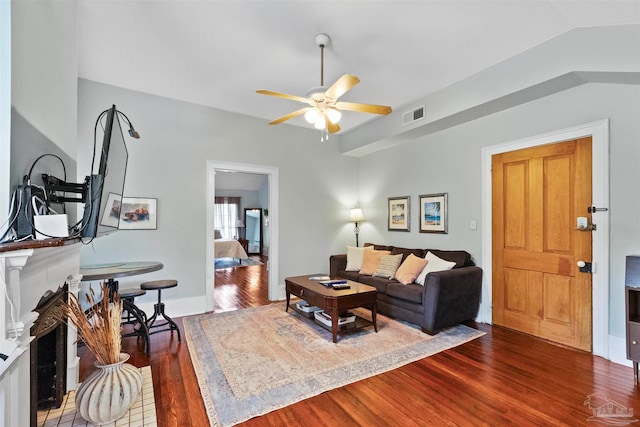 living room featuring wood-type flooring, vaulted ceiling, and ceiling fan