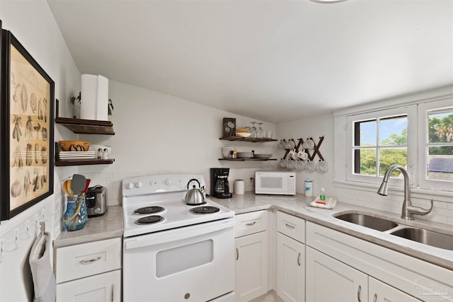 kitchen with white appliances, white cabinetry, sink, and tasteful backsplash