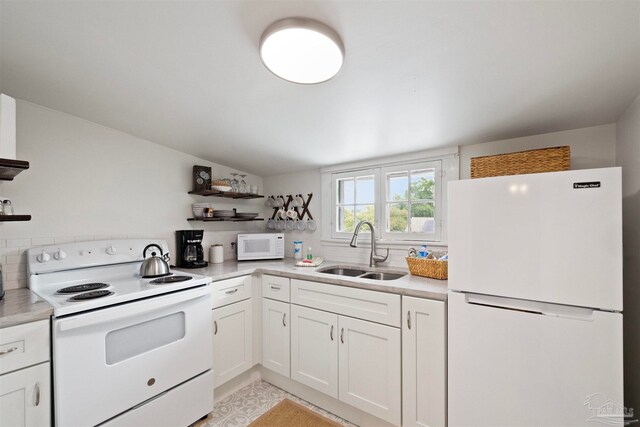 kitchen with decorative backsplash, white cabinets, white appliances, and sink