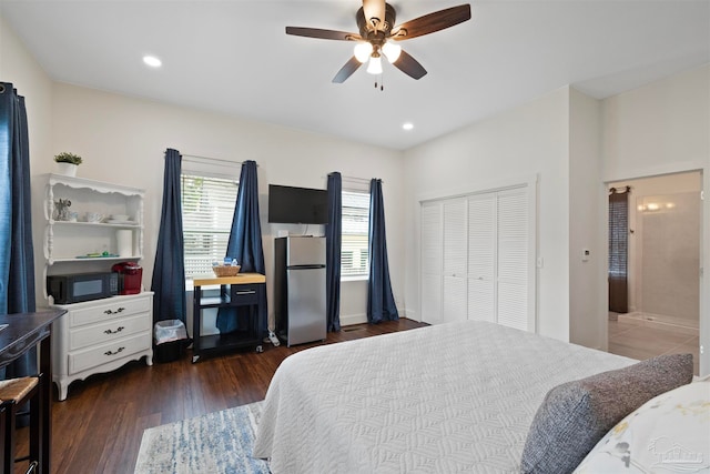 bedroom with a closet, ceiling fan, dark hardwood / wood-style floors, and stainless steel fridge