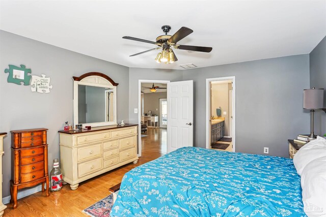 bedroom with a ceiling fan, visible vents, ensuite bathroom, and light wood finished floors