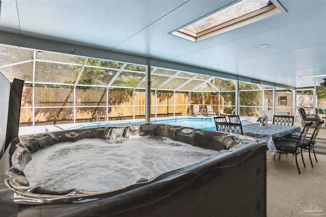 view of patio with a lanai, a hot tub, and a fenced backyard