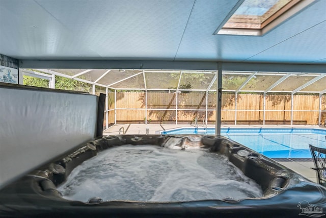 view of pool with a covered hot tub, a fenced backyard, a fenced in pool, and a lanai