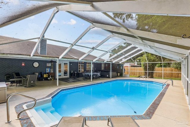 view of swimming pool with french doors, a fenced in pool, a fenced backyard, a lanai, and a patio