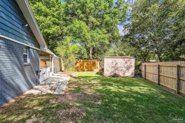 view of yard with a fenced backyard, an outdoor structure, and a storage shed