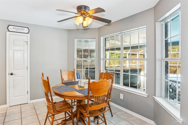 dining room with plenty of natural light, baseboards, a ceiling fan, and light tile patterned floors