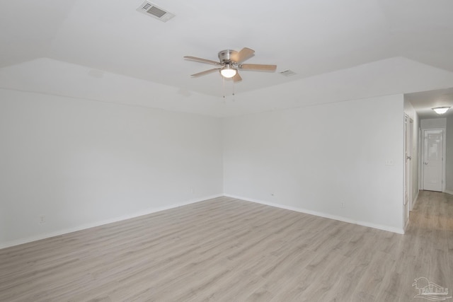 unfurnished room with a tray ceiling, ceiling fan, and light wood-type flooring