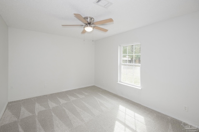 carpeted spare room featuring a textured ceiling and ceiling fan