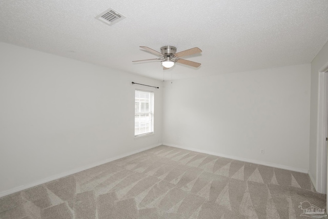 unfurnished room with ceiling fan, light carpet, and a textured ceiling