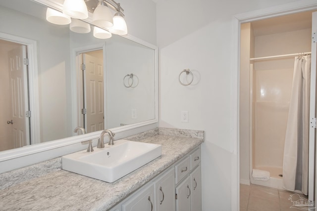 bathroom featuring tile patterned flooring, vanity, and curtained shower