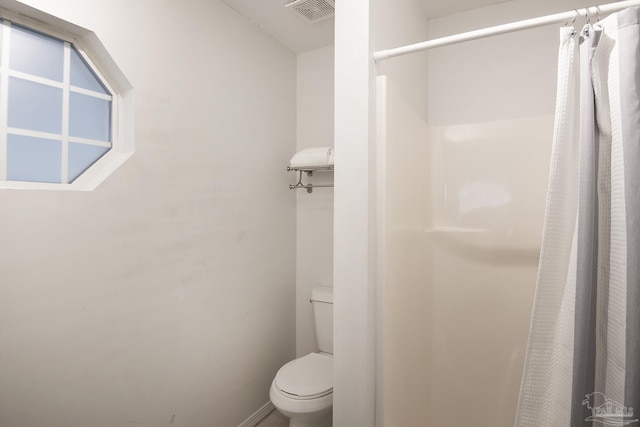 bathroom with a shower with curtain and toilet