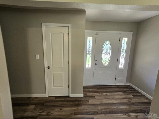 empty room with dark hardwood / wood-style flooring, a wealth of natural light, and ceiling fan