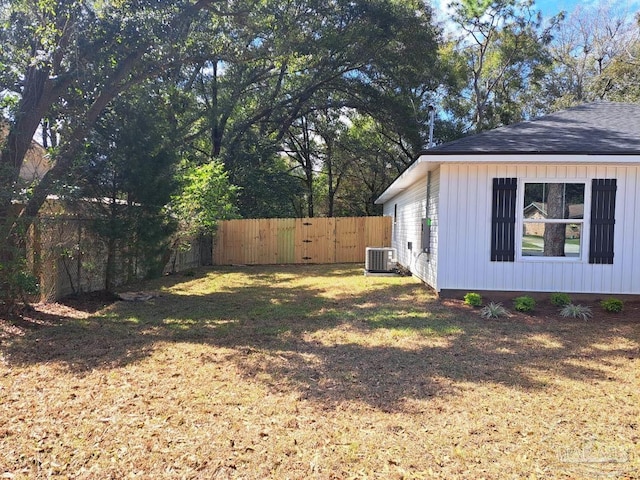 view of yard with central air condition unit and fence