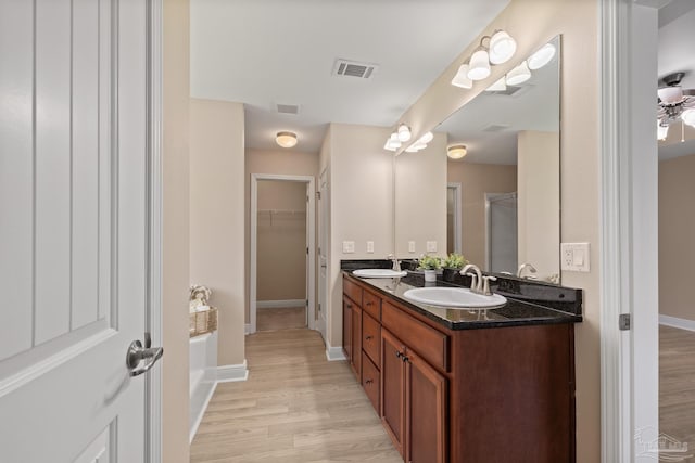 1804 Twin Pine Blvd, Gulf Breeze, FL 32563 - bathroom featuring double vanity, wood finished floors, a walk in closet, and a shower with shower door