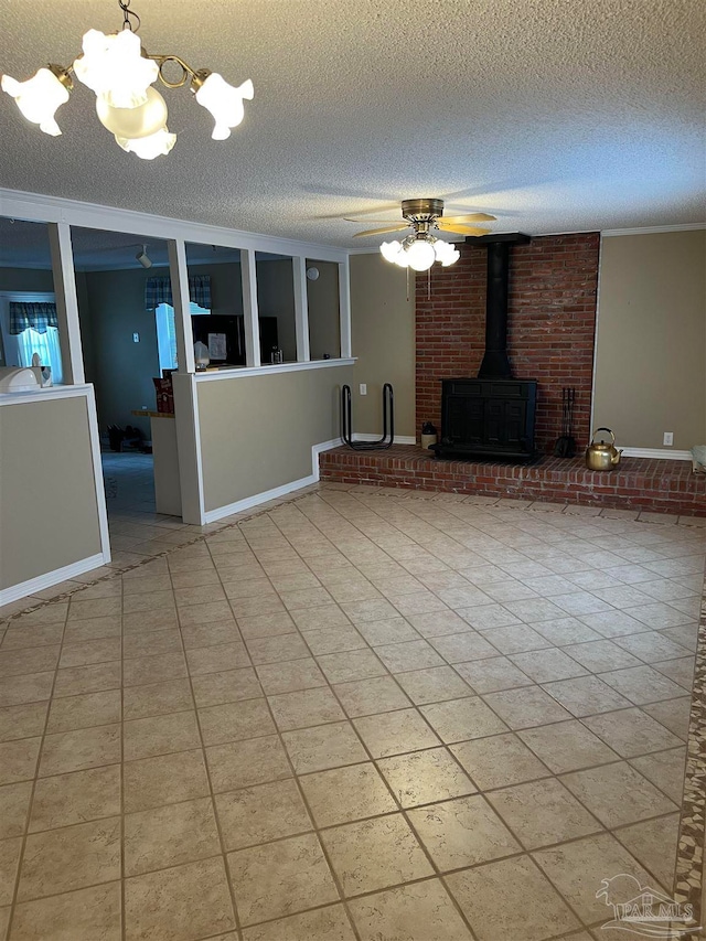 unfurnished living room featuring a wood stove, ceiling fan with notable chandelier, and a textured ceiling