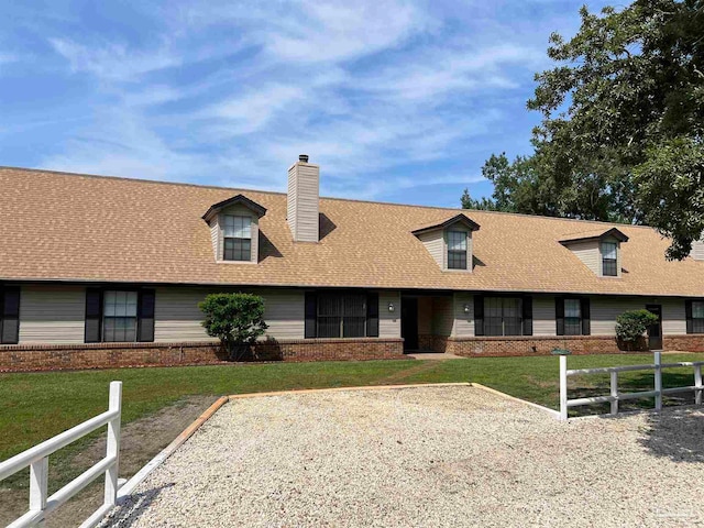 cape cod home featuring a front lawn