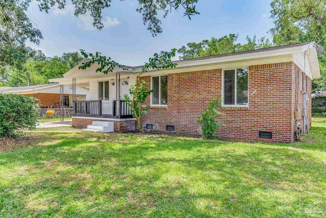 back of property featuring covered porch and a yard