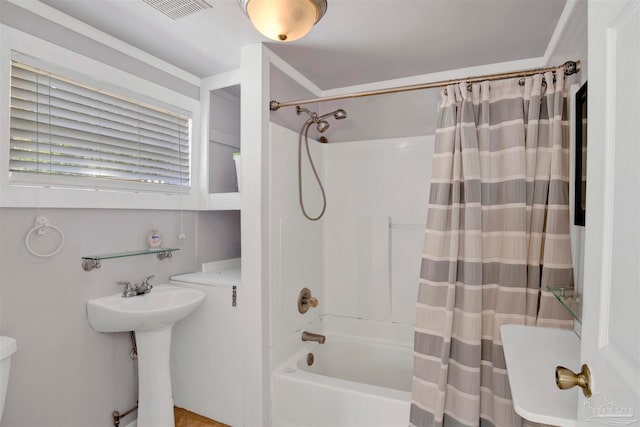 bathroom with shower / tub combo with curtain and sink