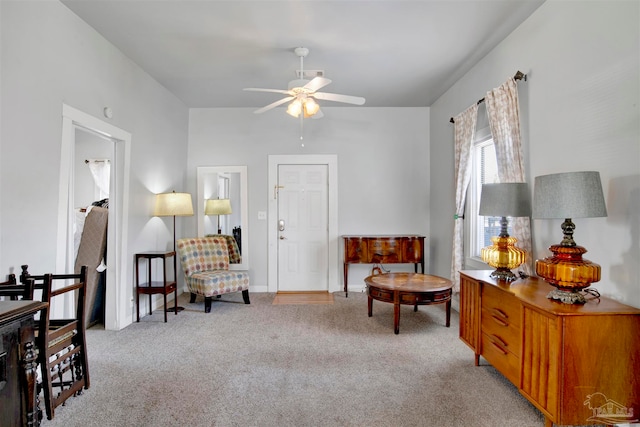 living area featuring light carpet and ceiling fan