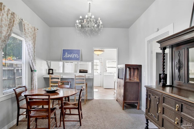 carpeted dining area featuring a wealth of natural light and a notable chandelier