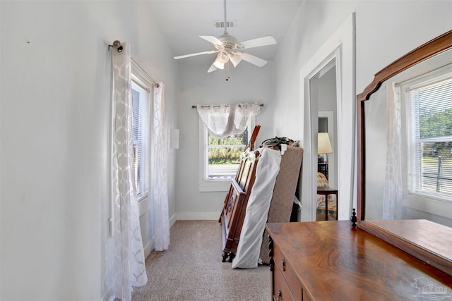 carpeted bedroom featuring lofted ceiling, multiple windows, and ceiling fan