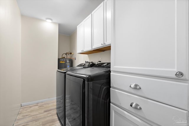 laundry room with cabinets, water heater, light hardwood / wood-style floors, and independent washer and dryer