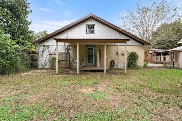 back of property featuring a lawn