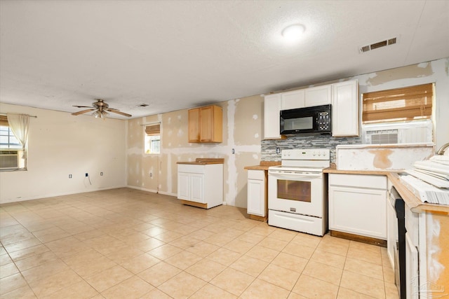 kitchen featuring a wealth of natural light, white cabinets, and black appliances