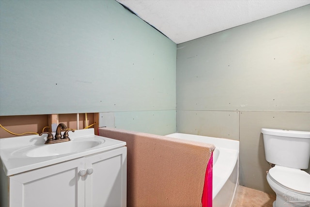 bathroom with a washtub, a textured ceiling, vanity, vaulted ceiling, and toilet