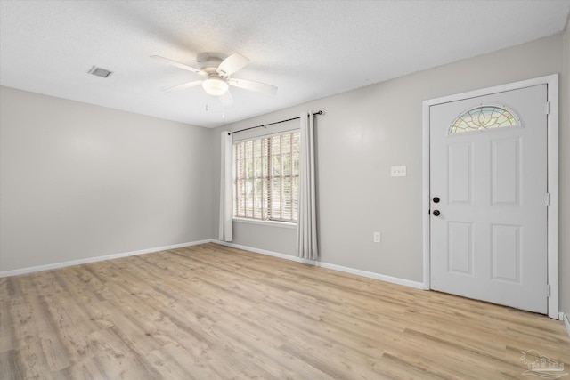 foyer entrance featuring ceiling fan, light hardwood / wood-style floors, and a textured ceiling