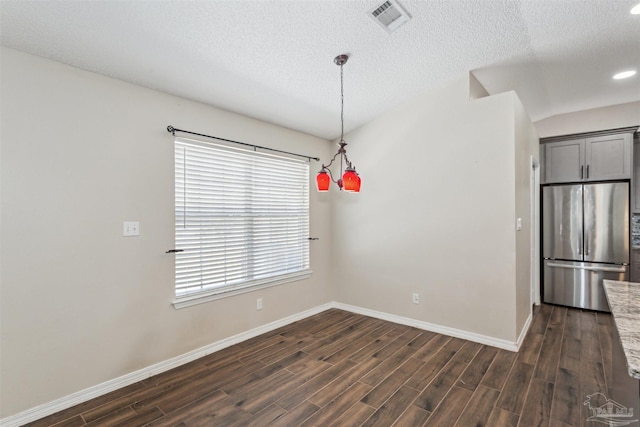 unfurnished dining area featuring dark hardwood / wood-style floors and a textured ceiling