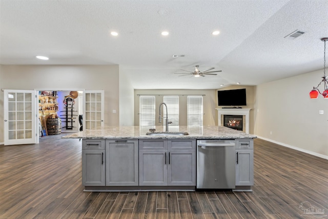 kitchen featuring sink, gray cabinets, dishwasher, dark hardwood / wood-style floors, and an island with sink