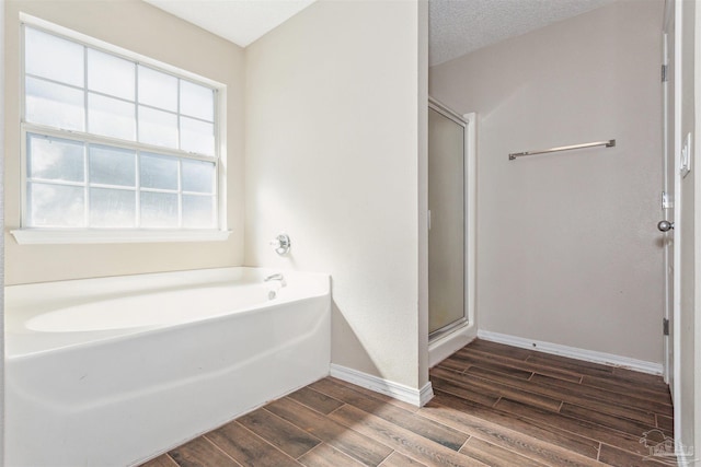 bathroom featuring plus walk in shower and a textured ceiling