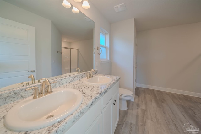 bathroom with a shower stall, baseboards, a sink, and wood finished floors