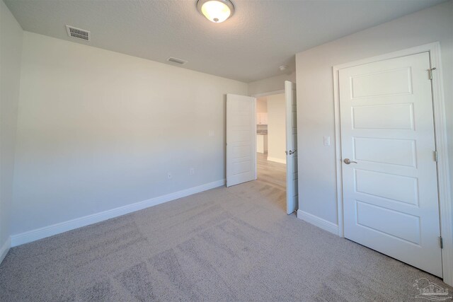 ensuite bathroom with visible vents, ensuite bathroom, a sink, wood finished floors, and plenty of natural light