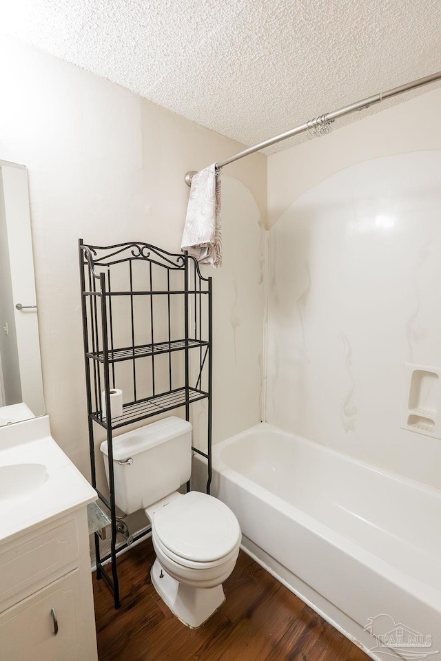 full bathroom featuring shower / bathing tub combination, vanity, a textured ceiling, toilet, and hardwood / wood-style flooring