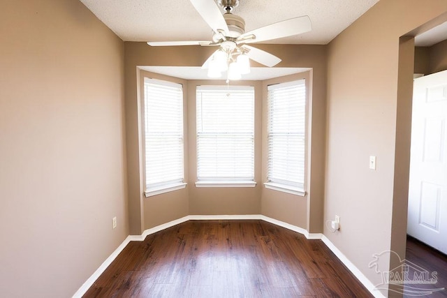 empty room with ceiling fan and dark hardwood / wood-style flooring