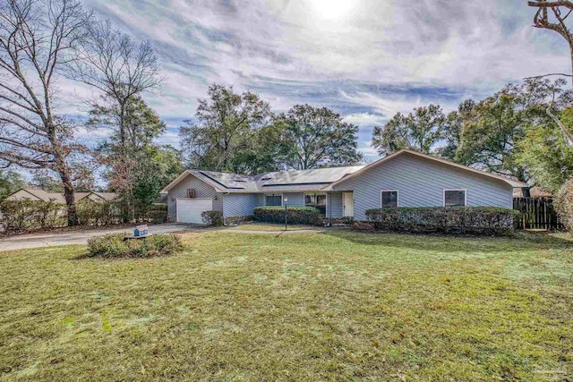 ranch-style house with a garage, a front yard, and solar panels