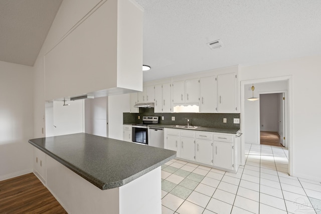 kitchen with stainless steel appliances, white cabinetry, tasteful backsplash, and kitchen peninsula