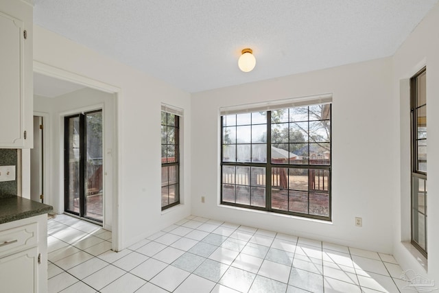 unfurnished dining area featuring light tile patterned floors and a wealth of natural light