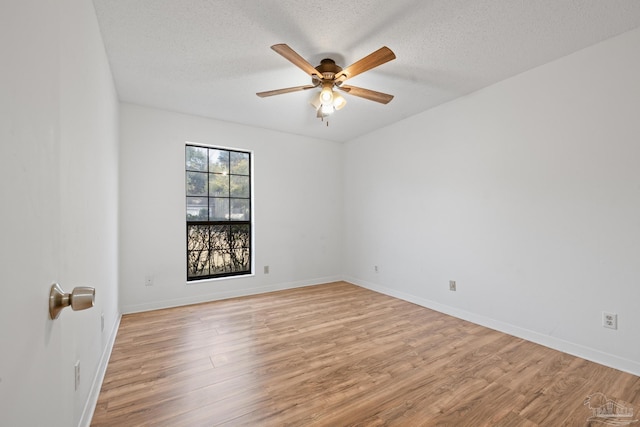 unfurnished room featuring ceiling fan, light hardwood / wood-style floors, and a textured ceiling