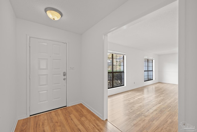 foyer with a textured ceiling and light wood-type flooring