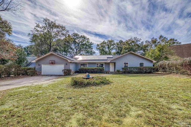 ranch-style home with a garage, a front yard, and solar panels