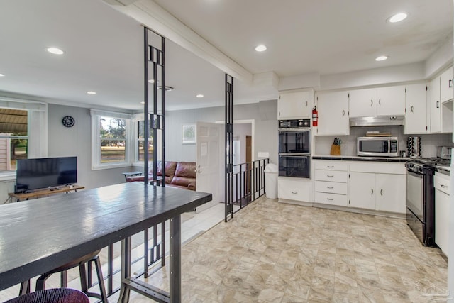 kitchen featuring tasteful backsplash, open floor plan, black appliances, white cabinetry, and recessed lighting