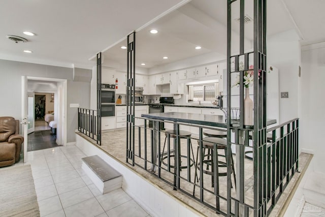 hallway featuring light tile patterned floors, visible vents, and recessed lighting