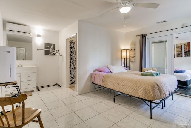 bedroom featuring light tile patterned floors, baseboards, visible vents, an AC wall unit, and a sink