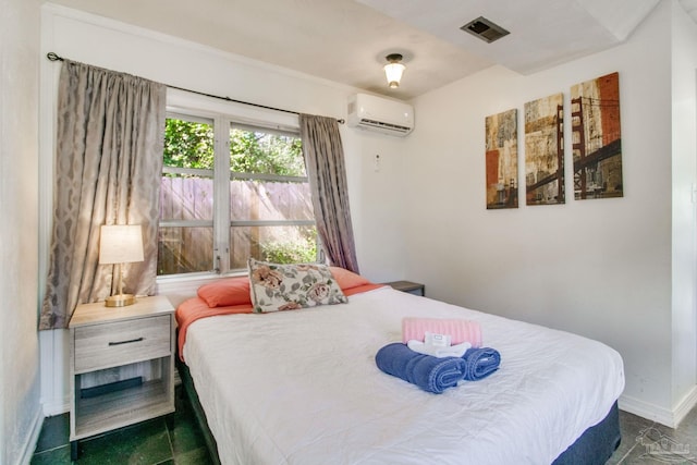 bedroom with an AC wall unit, visible vents, and baseboards